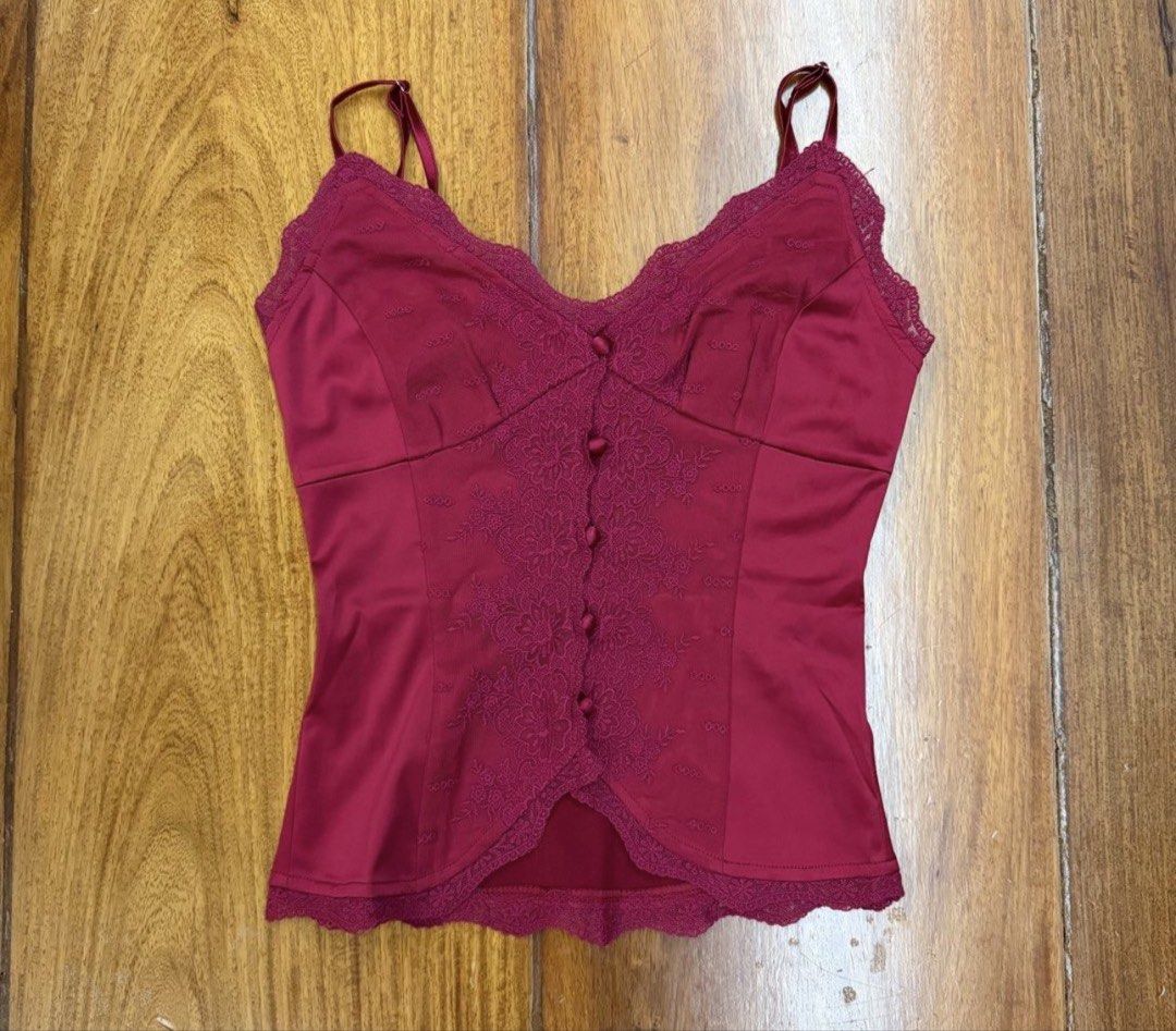 Princess Polly- Red Top (Category: Sleeveless) located in San Juan City. Submitted by Goodstuffhere (Listing ID 1468712408, Image 1). Description: - Color: Rich deep red - Material: Smooth, silky fabric - Design: Delicate floral lace down the center front with fabric-covered buttons - Fit: Adjustable spaghetti straps - Details: Scalloped hem and neckline - Versatility: Perfect for layering or warm weather wear.