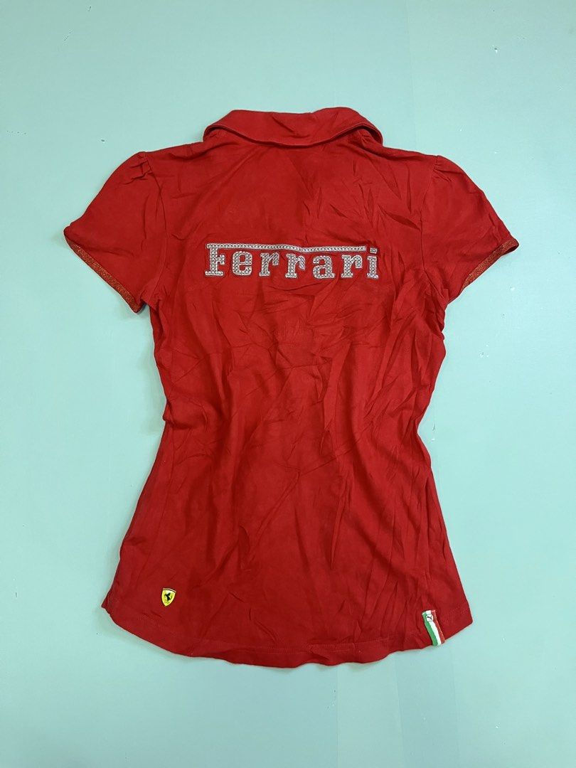 Puma Ferrari Red Polo Shirt (Category: Tshirts & Polo Shirts ) located in Mabalacat. Submitted by aas_thriftfings (Listing ID 1468572977, Image 2). Description: - Brand: Puma x Scuderia Ferrari - Color: Red with silver sparkly detailing - Logos: Ferrari shield on chest, Puma cat logo near hem - Unique Details: Sparkly Ferrari lettering on back shoulders, multi-colored front buttons, star-shaped bottom button - Accents: Italian flag colors on coll