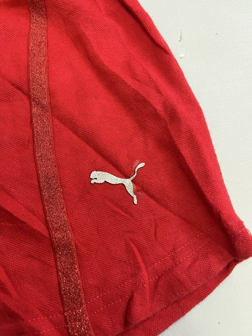 Puma Ferrari Red Polo Shirt (Category: Tshirts & Polo Shirts ) located in Mabalacat. Submitted by aas_thriftfings (Listing ID 1468572977, Image 3). Description: - Brand: Puma x Scuderia Ferrari - Color: Red with silver sparkly detailing - Logos: Ferrari shield on chest, Puma cat logo near hem - Unique Details: Sparkly Ferrari lettering on back shoulders, multi-colored front buttons, star-shaped bottom button - Accents: Italian flag colors on coll