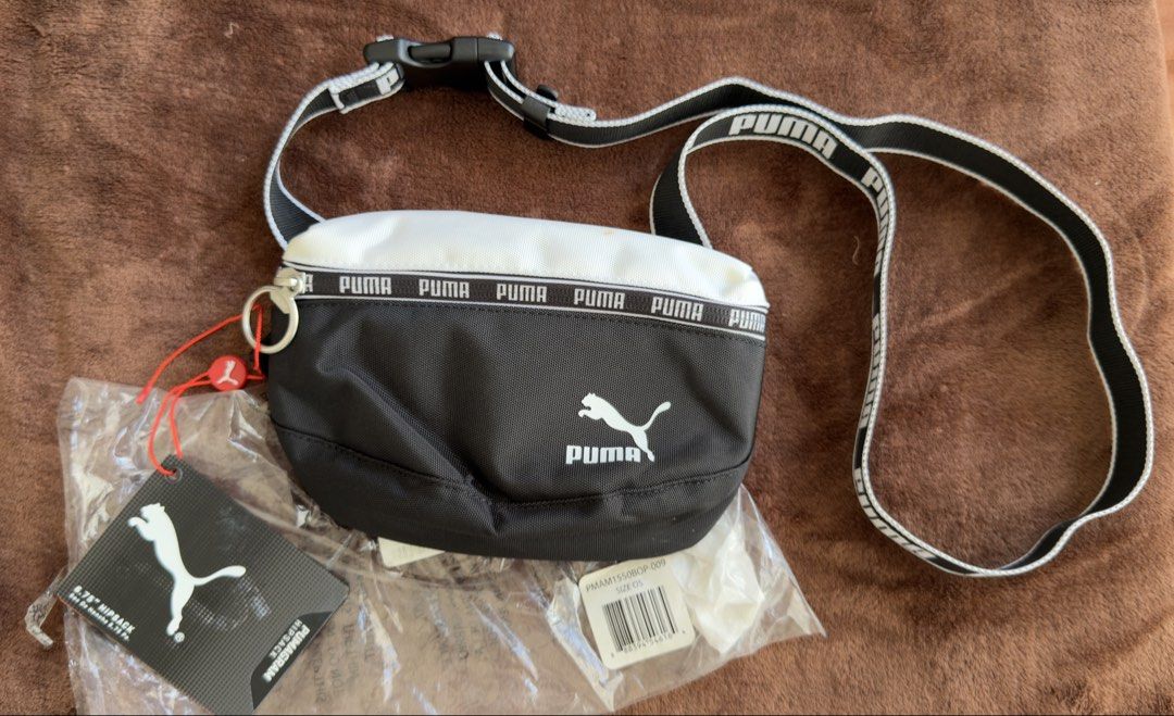 Puma Hip Pack Bum Bag Black White (Category: Babies & Kids Fashion) located in Cainta. Submitted by sixteenfive29 (Listing ID 1468606732, Image 1). Description: - Brand: Puma - Color: Classic Black and White - Size: Standard OSFA (One Size Fits All) - Features: Adjustable strap with buckle, zippered main compartment, and inner tag - Condition: Brand new with original hang tags in packaging; has a small, faint orange stain on the white fabric near