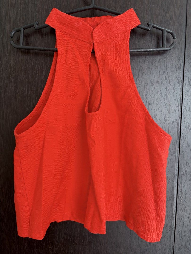 Carino Red Halter Neck Crop Top (Category: Sleeveless) located in Pasig City. Submitted by marias_wardrobe (Listing ID 1468512725, Image 1). Description: - Color: Bright red - Style: Halter neck, sleeveless, cropped length - Details: Button closure at back collar with a stylish open teardrop cutout - Material: Textured woven fabric.