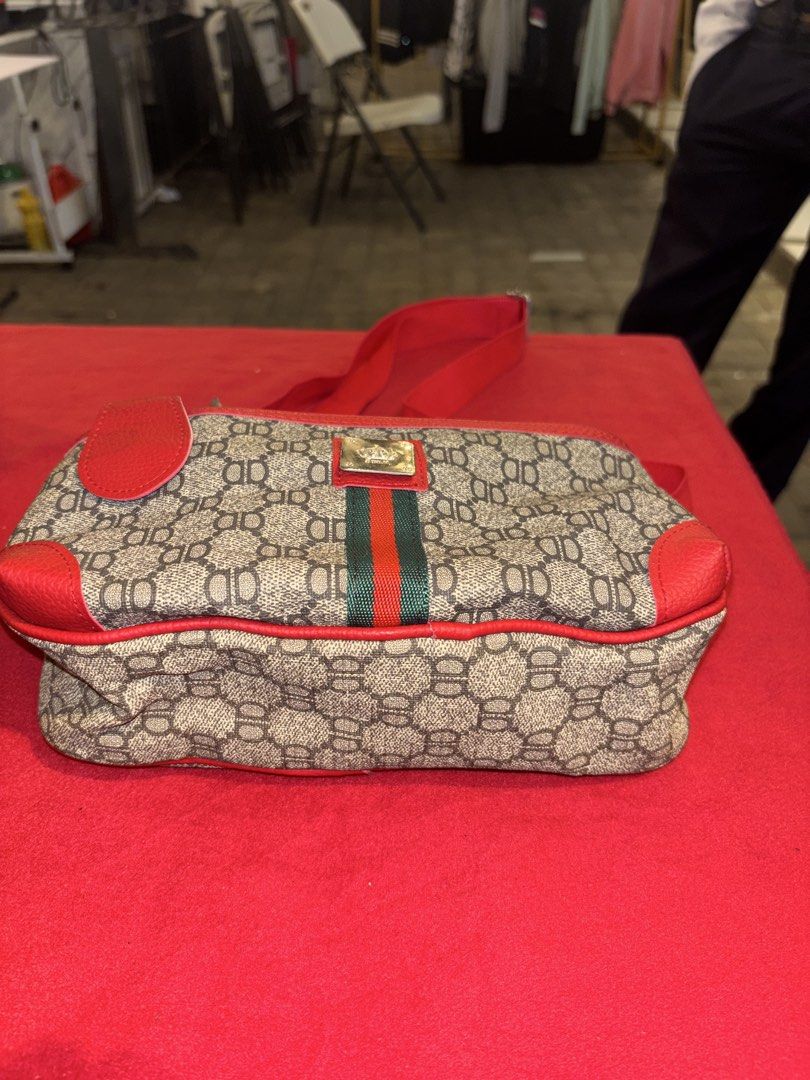 Red patterned crossbody shoulder bag with zipper pockets (Category: Cross-body Bags) located in Manila. Submitted by jeromskito66462 (Listing ID 1468669651, Image 2). Description: - Style: Monogram crossbody bag with vibrant red leather trim - Colors: Red and beige with gold-tone hardware - Pockets: Front flap pocket, main zippered compartment, back zipper pocket, and an inner zipper pocket - Interior: Clean black fabric lining - Details: Feature