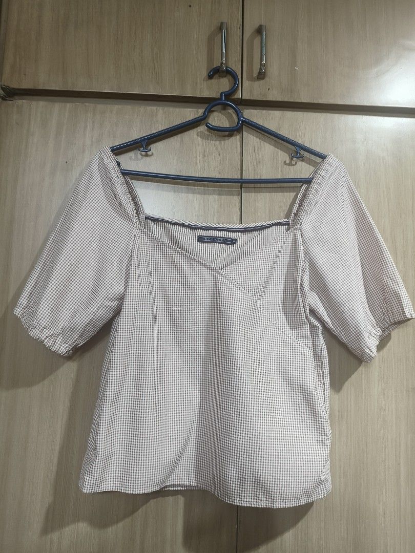 Regatta blouse (Category: Blouses) located in Quezon City. Submitted by majasaw88 (Listing ID 1468573014, Image 1). Description: - Brand: Regatta - Size: Medium - Design: Brown and white checkered print, square neckline, wrap-style front - Sleeves: Short puff sleeves with elastic cuffs - Fabric: Lightweight, ideal for warm weather and casual wear.