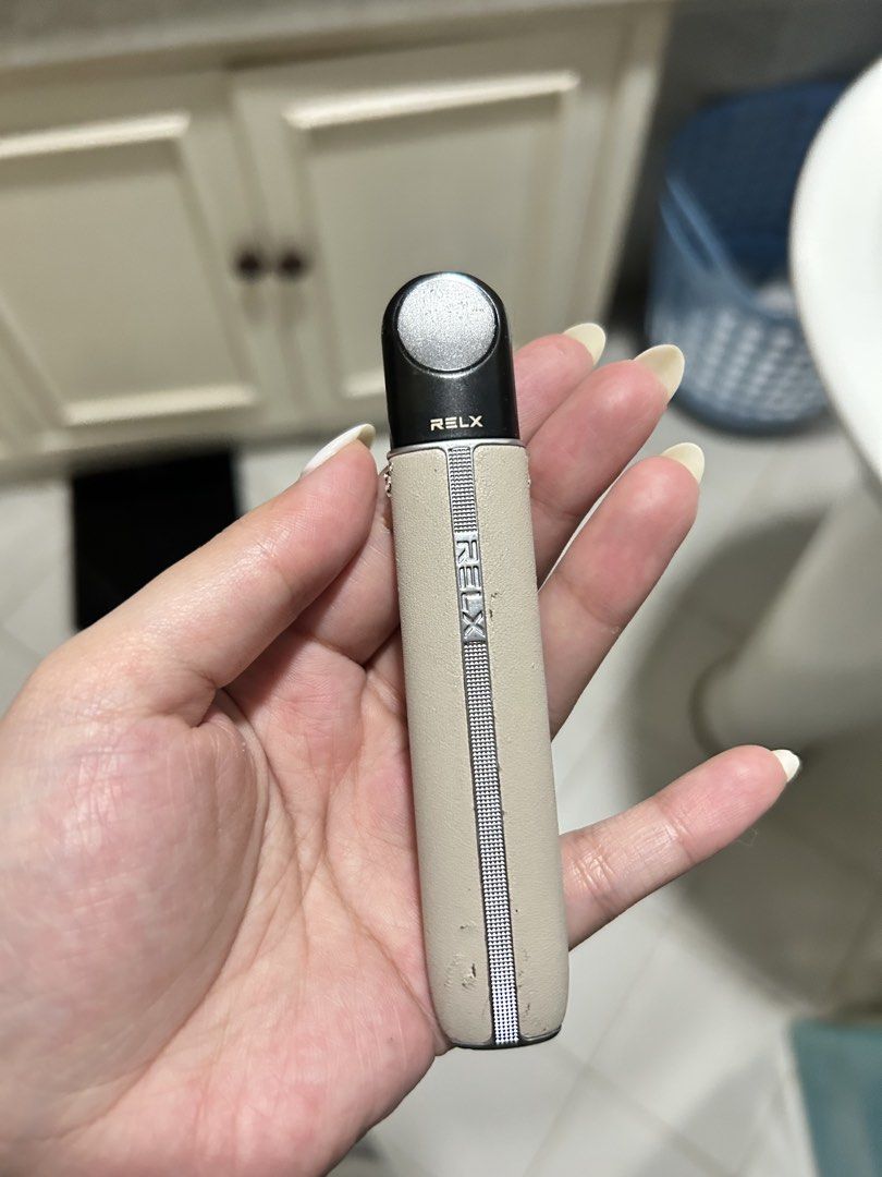 RELX Infinity 2 vape device with pods bundle (Category: Other Gadgets) located in Paranaque City. Submitted by cece14237 (Listing ID 1468561618, Image 2). Description: - Item: RELX Infinity 2 Device Artisan with Pods Bundle - Color/Material: Beige Leather Wrap (Note: minor peeling and wear on the vertical strip) - Pods Included: 3 sealed Pod Pro 2 boxes - Flavors: Lemon Ice Tea, Hibiscus Ice Tea, and Green Grape Ice - Nicotine Strength: 3% (1.9ml
