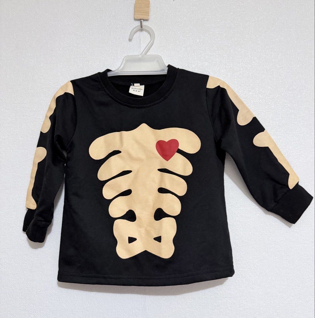 Ribcage design (Category: Babies & Kids Fashion) located in Dasmarinas. Submitted by elizmaebau68309 (Listing ID 1468631014, Image 1). Description: black long-sleeve children’s top with a cream-colored skeleton ribcage print and a red heart accent. 2-3 years old Excellent condition .