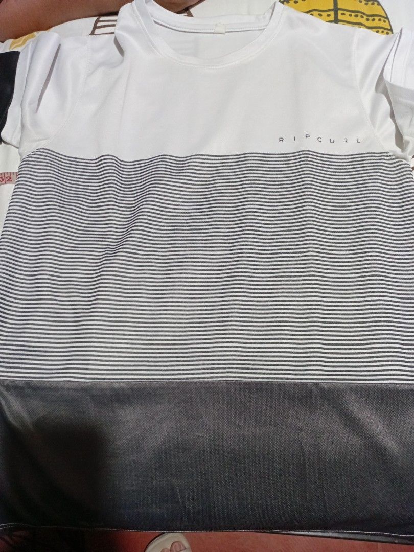 Rip Curl Striped Athletic T-Shirt (Category: Tshirts & Polo Shirts ) located in Las Pinas. Submitted by jaziyah4 (Listing ID 1468539023, Image 1). Description: - Brand: Rip Curl - Color: White with striped center panel and dark sleeve block - Material: 100% breathable polyester (lightweight) - Fit: Standard fit - Style: Crew neck, short sleeves - Ideal for: Workouts and casual wear - width 19.5 inches and length 25 inches P399 each.