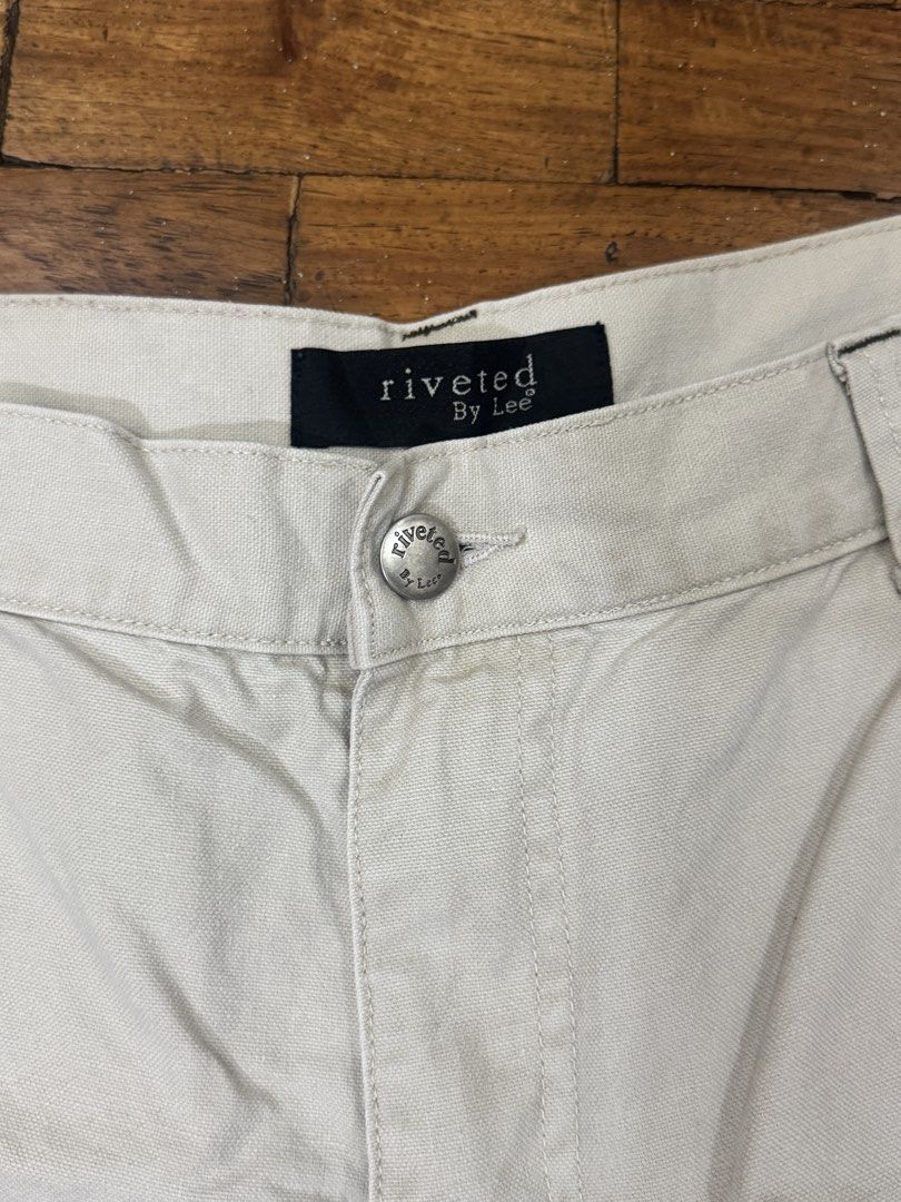Riveted By Lee Beige Cargo Shorts (Category: Shorts) located in Manila. Submitted by pringlesssy (Listing ID 1468630134, Image 2). Description: - Brand: Riveted By Lee - Color: Classic beige - Material: Durable cotton twill fabric - Fit & Closure: Front button and zip closure with belt loops - Pockets: Front slash pockets, side cargo pockets with metal ring detail, and back patch pockets with branded tag - Style: Casual everyday staple, great for