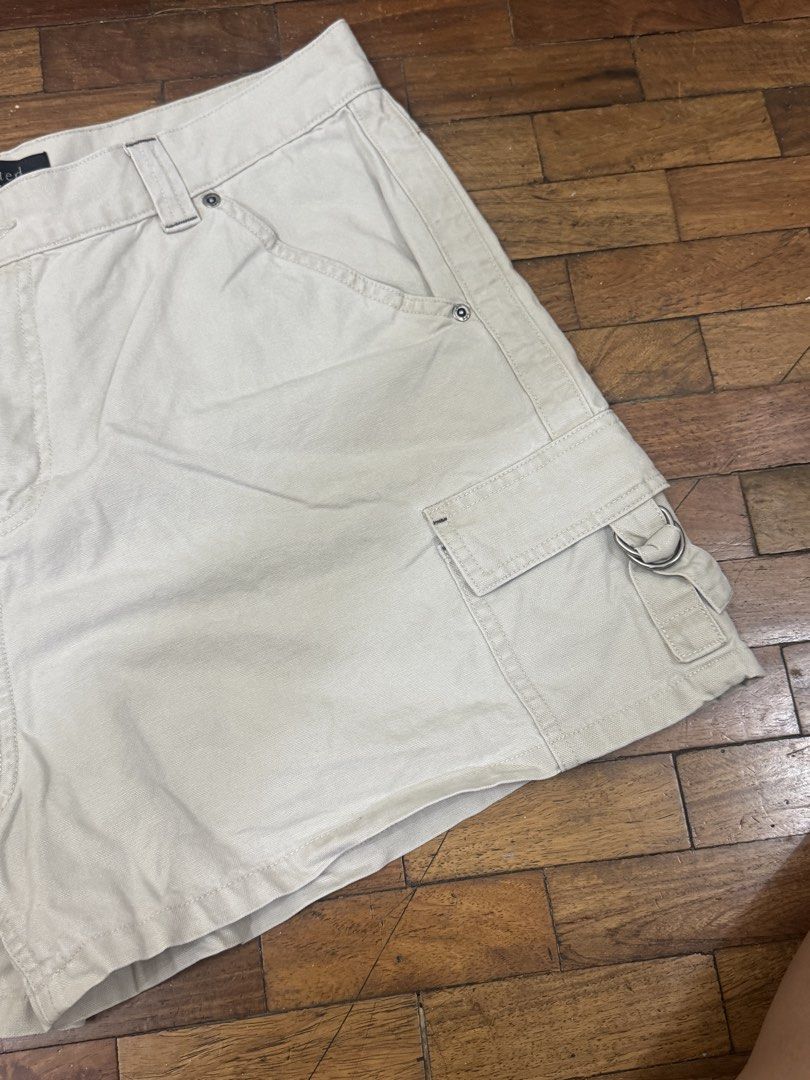 Riveted By Lee Beige Cargo Shorts (Category: Shorts) located in Manila. Submitted by pringlesssy (Listing ID 1468630134, Image 3). Description: - Brand: Riveted By Lee - Color: Classic beige - Material: Durable cotton twill fabric - Fit & Closure: Front button and zip closure with belt loops - Pockets: Front slash pockets, side cargo pockets with metal ring detail, and back patch pockets with branded tag - Style: Casual everyday staple, great for