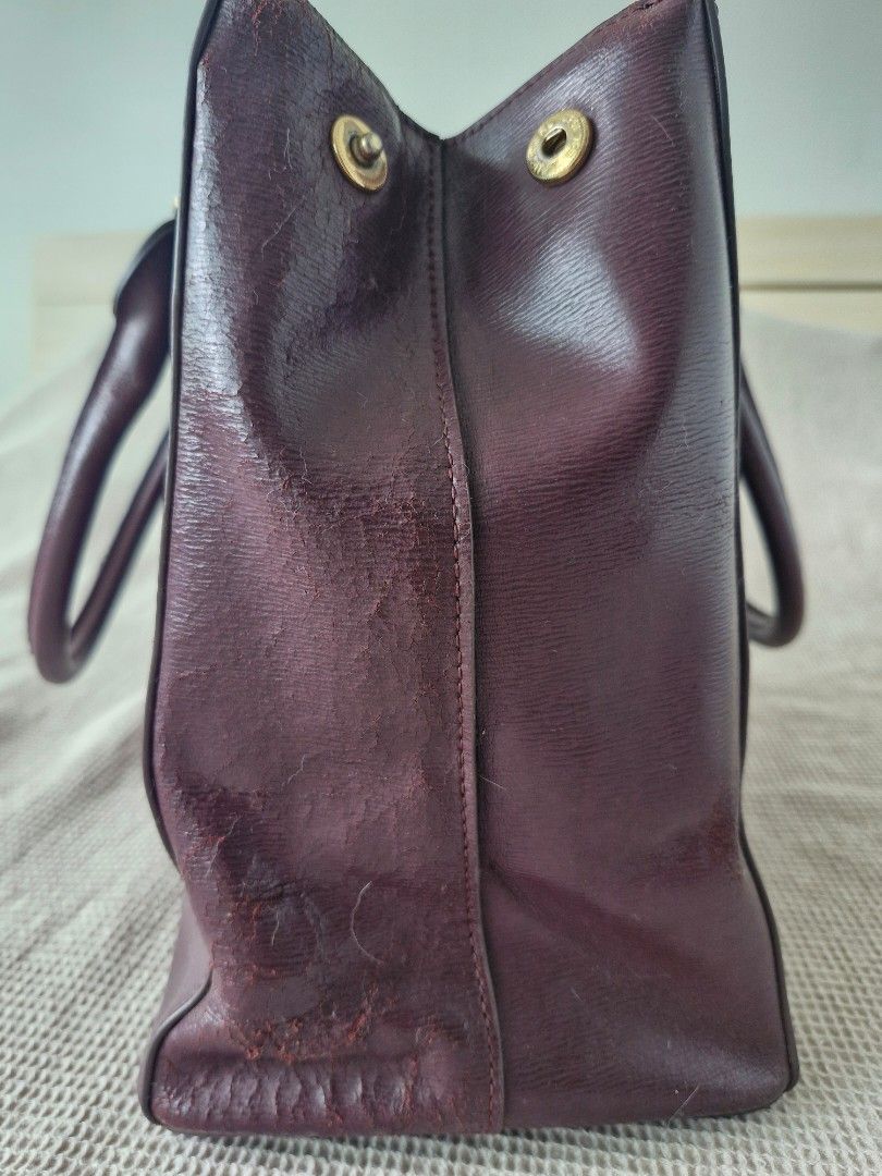 RLL Burgundy Leather Tote Bag (Category: Tote Bags) located in Quezon City. Submitted by acey18 (Listing ID 1468569299, Image 3). Description: - Brand: LRalph Lauren (RLL) - Style: Structured tote bag in a rich dark burgundy leather - Hardware: Elegant gold-tone accents with front embossed RLL monogram - Interior: Multiple zip compartments and handy slip pockets - Closure: Rolled top handles and magnetic snap gussets - strap included - Condition: