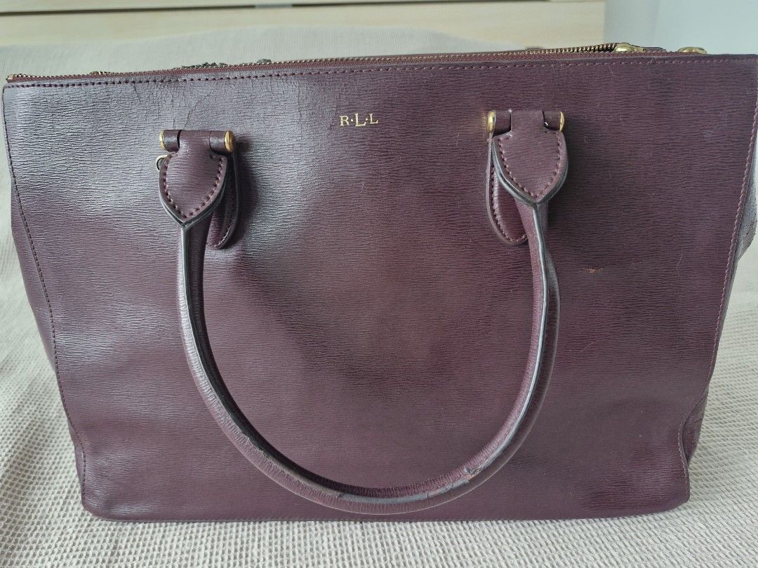 RLL Burgundy Leather Tote Bag (Category: Tote Bags) located in Quezon City. Submitted by acey18 (Listing ID 1468569299, Image 1). Description: - Brand: LRalph Lauren (RLL) - Style: Structured tote bag in a rich dark burgundy leather - Hardware: Elegant gold-tone accents with front embossed RLL monogram - Interior: Multiple zip compartments and handy slip pockets - Closure: Rolled top handles and magnetic snap gussets - strap included - Condition: