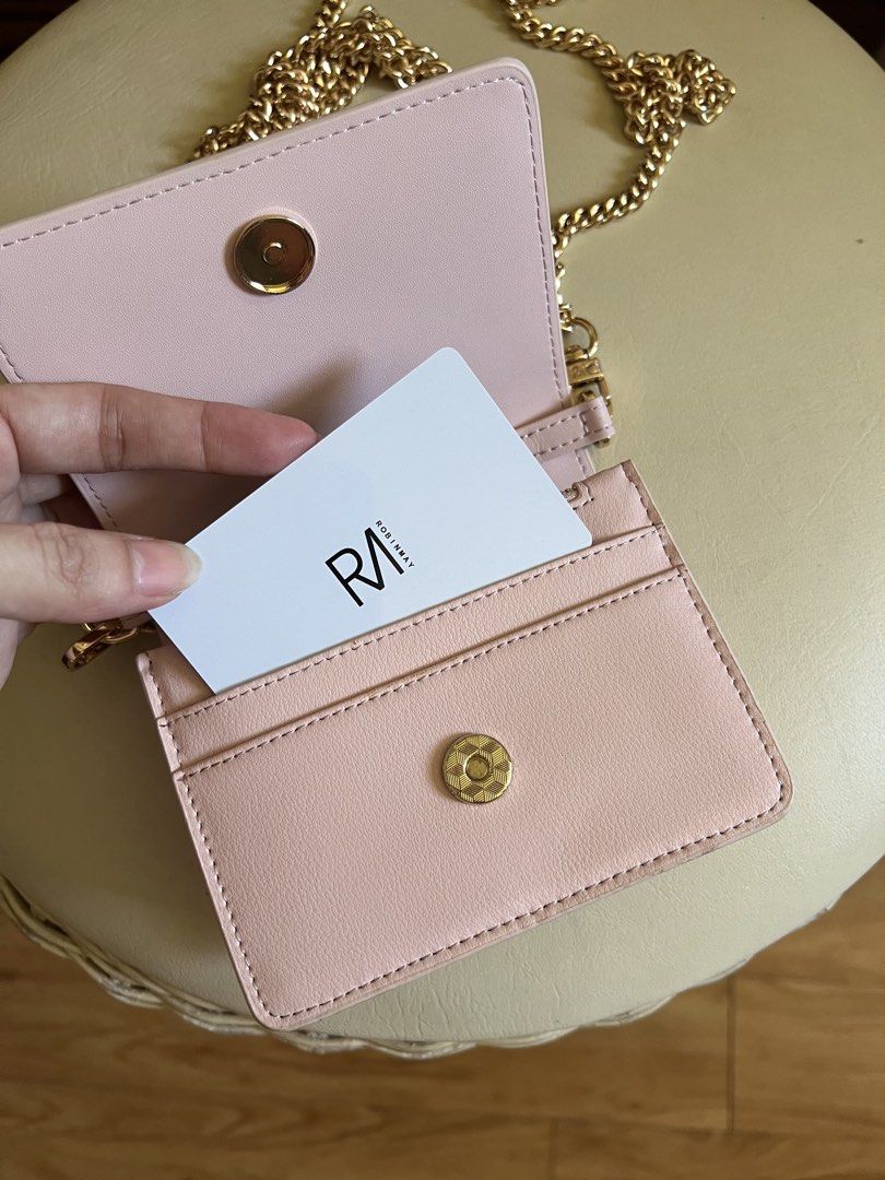 ROBINMAY Pink Crossbody Bag Chain Strap (Category: Cross-body Bags) located in Rizal. Submitted by s0apandglory (Listing ID 1468561226, Image 2). Description: - Brand: ROBINMAY Never used bought in Taiwan - Color: Pastel Pink faux leather - Hardware: Gold-tone chain strap with branded metal tag and clear RM logo - Closure: Front flap with magnetic snap - Interior: Includes card slots and a zipped compartment - Size: Mini/Compact, ideal for carryi