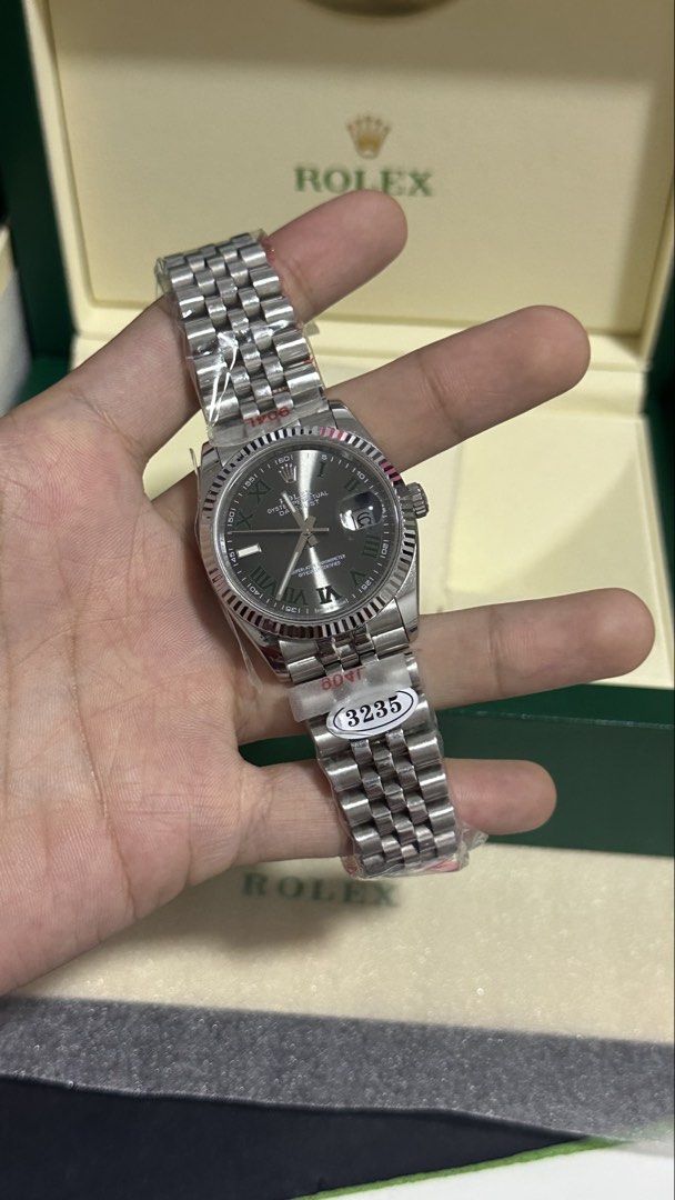 Rolex Datejust 36 "Wimbledon" Dial (Midtier) (Category: Luxury Watches) located in Balanga. Submitted by garahehub (Listing ID 1468501538, Image 3). Description: - Model Style: Datejust 36 - Tier / Quality: Midtier - Dial: Slate Grey “Wimbledon” Dial with Green Roman Numerals - Movement: Automatic Movement (3235 Engraved) - Bezel: Fluted Bezel - Bracelet: Jubilee Bracelet (904L Steel Marked) - Glass: Sapphire Glass with Cyclops Date Lens - Inclus