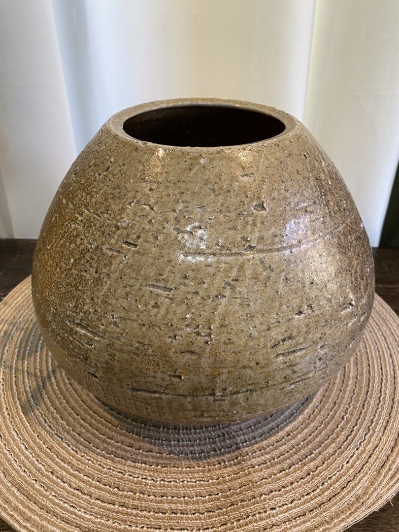 Round Textured Brown Ceramic Vase (Category: Vases & Decorative Bowls) located in San Pedro. Submitted by jingay81 (Listing ID 1468708696, Image 2). Description: - Type: Round ceramic vase - Color/Finish: Earthy brown with speckled glaze - Design: Textured exterior with horizontal scored lines - Size: Approx. 7 inches tall - Best for: Dried branches or floral arrangements - Style: Neutral tone that matches most home decor.