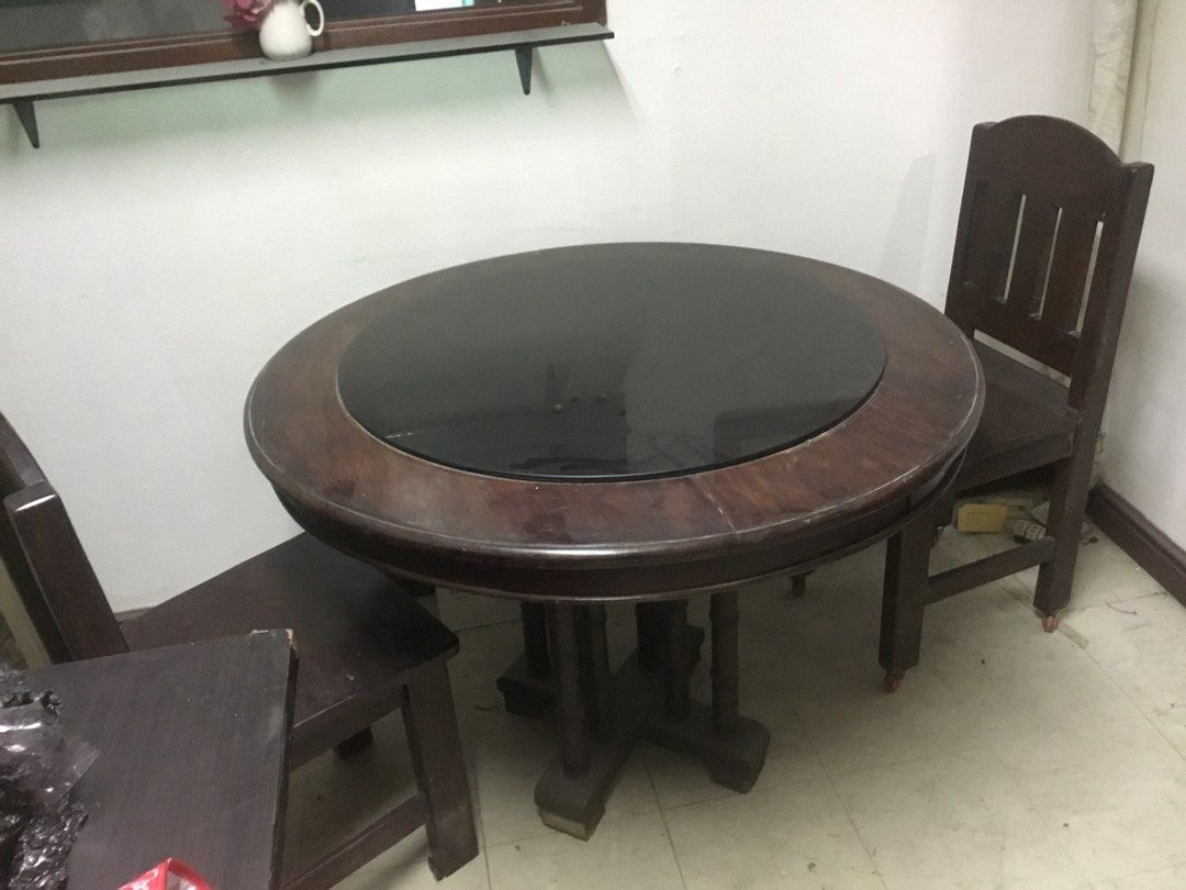 Round Wooden Dining Table with Chairs (Category: Tables & Sets) located in Manila. Submitted by roberto.enriquez (Listing ID 1468689718, Image 2). Description: - Dark wood round dining table - Stylish black glass top insert in the middle - Includes matching dark wooden chairs with comfortable slatted backs - Sturdy pedestal base design for maximum support - Normal wear on wood surfaces from regular use - Pick up only Diameter Height .