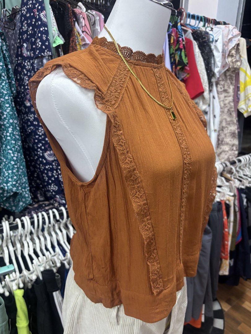 Rust Brown Lace Trim Sleeveless Tie-Back Top (Category: Sleeveless) located in Alicia. Submitted by thriftbagph (Listing ID 1468636017, Image 2). Description: -Small to semi med size - Color: Rust brown - Style: Sleeveless top with mock neck - Details: Delicate lace trim on collar and arm openings, vertical crochet lace panels on front - Back Design: Keyhole opening with top button and self-tie bow at the hem - Fabric: Lightweight and textured - 