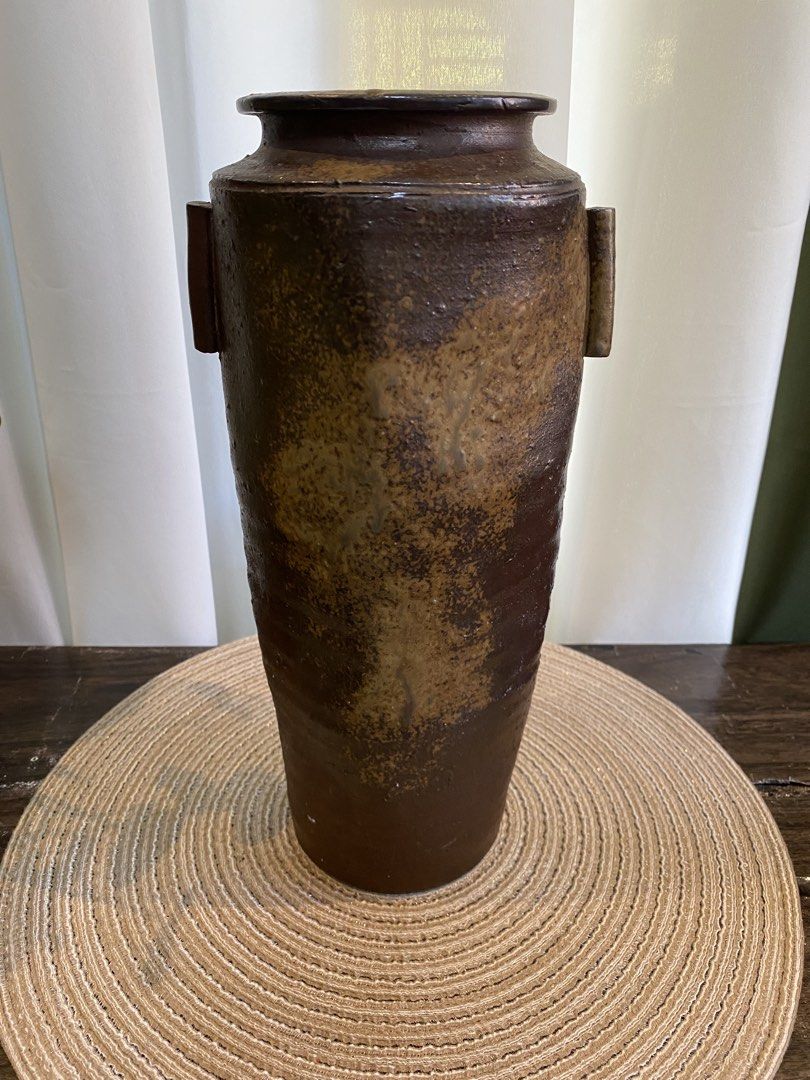 Rustic brown ceramic pottery vase with side handles (Category: Vases & Decorative Bowls) located in San Pedro. Submitted by jingay81 (Listing ID 1468708706, Image 1). Description: - Handmade ceramic pottery vase - Deep dark brown glaze with textured earth-tone patches - Features two vertical side handles and a flat stable base - Stands approximately 13 inches tall - Heavyweight stoneware with an organic, wabi-sabi aesthetic - Clean interior, idea