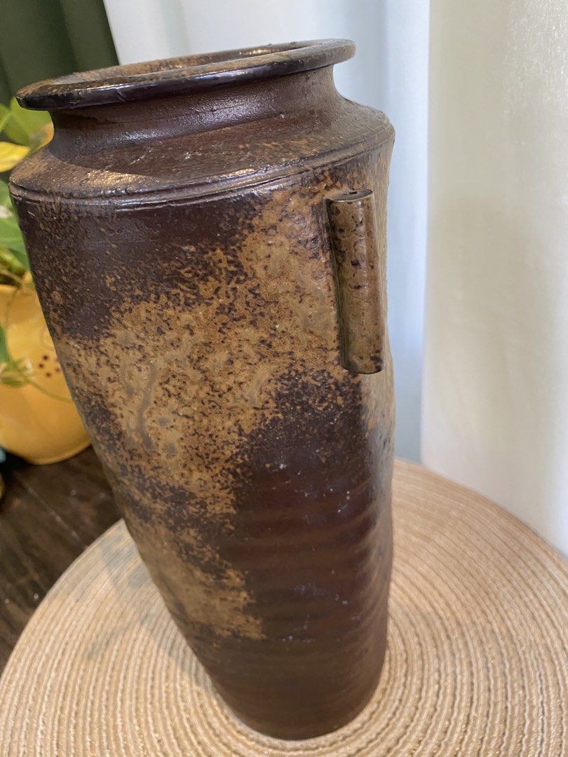 Rustic brown ceramic pottery vase with side handles (Category: Vases & Decorative Bowls) located in San Pedro. Submitted by jingay81 (Listing ID 1468708706, Image 2). Description: - Handmade ceramic pottery vase - Deep dark brown glaze with textured earth-tone patches - Features two vertical side handles and a flat stable base - Stands approximately 13 inches tall - Heavyweight stoneware with an organic, wabi-sabi aesthetic - Clean interior, idea