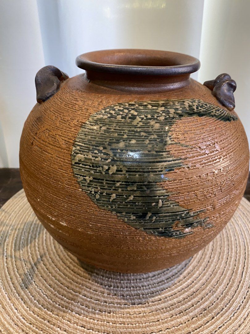 Rustic textured ceramic pottery vase with handles (Category: Vases & Decorative Bowls) located in San Pedro. Submitted by jingay81 (Listing ID 1468708681, Image 2). Description: - Round textured ceramic vase in earthy brown tones - Features a striking dark brushed glaze accent on the front - Elegant ribbed finish throughout the body - Small sculpted handles on opposite sides of the rim - Wide circular top opening and solid base - Unique handcraft
