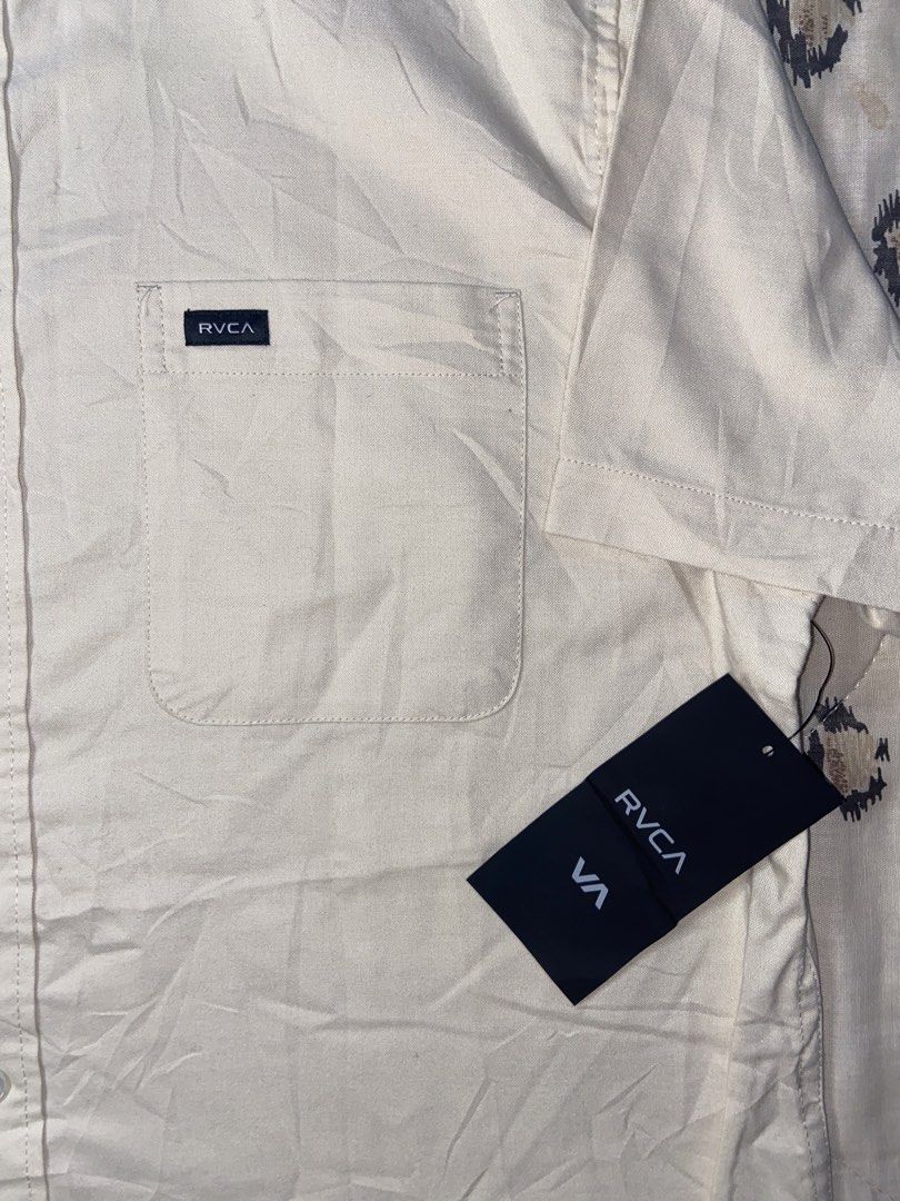 RVCA Short Sleeve Button Down Shirt Slim Fit Medium (Category: Tshirts & Polo Shirts ) located in Manila. Submitted by nix.thrift (Listing ID 1468608246, Image 3). Description: - Brand: RVCA - Style: Short sleeve button-down shirt with button-down collar - Color: Cream - Size: Men's Medium (Slim Fit) - Details: Single chest pocket with woven brand label - Condition: Brand new with original tags attached, unworn.