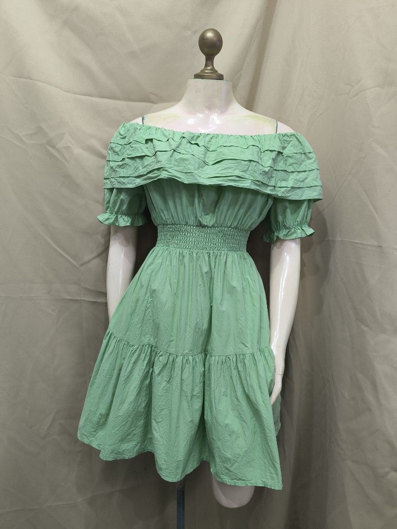 Sage Green Off-Shoulder Ruffle Mini Dress (Category: Dresses) located in Marikina City. Submitted by mrlfashion23 (Listing ID 1468594931, Image 1). Description: - Color: Sage green - Style: Off-shoulder dress with a tiered skirt - Details: Ruffled neckline and short sleeves - Waist: Smocked elastic for a comfortable, stretchy fit - Material: Light and breezy fabric - Occasion: Great for casual outings and dates.
