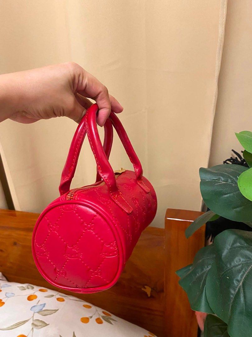 Sanrio Hello Kitty Red Quilted Cylinder Handbag (Category: Purses & Pouches) located in Manila. Submitted by janetecson05 (Listing ID 1468645731, Image 3). Description: Hk MINISO BAG Red Sanrio Kitty barrel handbag. Quilted pattern with embossed Kitty faces across the faux leather exterior. Gold hardware, including a cute bow-shaped zipper pull. Matching red fabric lining inside decorated with little Kitty outlines and bows. Dual top handles and 