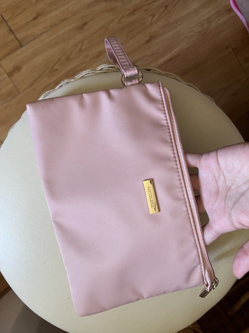 Secosana Pink Wristlet Clutch Pouch (Category: Clutches) located in Rizal. Submitted by s0apandglory (Listing ID 1468557627, Image 2). Description: - Brand: Secosana - Material: Durable nylon in a chic dusty pink shade - Hardware: Elegant gold-toned hardware with front metal logo - Strap: Includes a matching detachable wrist strap - Closure: Top zip with a branded pull tab - Interior: Clean grey lining with one main compartment, slip pockets, and