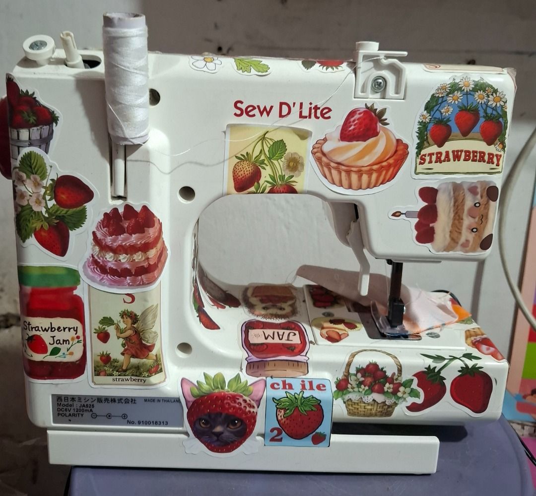 Sew D'Lite JA525 Strawberry Sewing Machine (Category: Craft Supplies & Tools) located in Paranaque City. Submitted by strawberryeng (Listing ID 1468578044, Image 3). Description: - Model: Sew D'Lite JA525 mini sewing machine - Custom design: Covered with adorable strawberry and dessert stickers - Condition: Tested and stitches properly on fabric scrap - Power: Works on DC6V 1200mA power - Inclusions: Matching foot pedal controller included - Idea