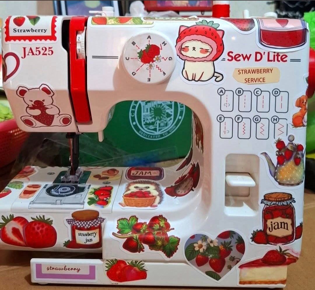 Sew D'Lite JA525 Strawberry Sewing Machine (Category: Craft Supplies & Tools) located in Paranaque City. Submitted by strawberryeng (Listing ID 1468578044, Image 1). Description: - Model: Sew D'Lite JA525 mini sewing machine - Custom design: Covered with adorable strawberry and dessert stickers - Condition: Tested and stitches properly on fabric scrap - Power: Works on DC6V 1200mA power - Inclusions: Matching foot pedal controller included - Idea