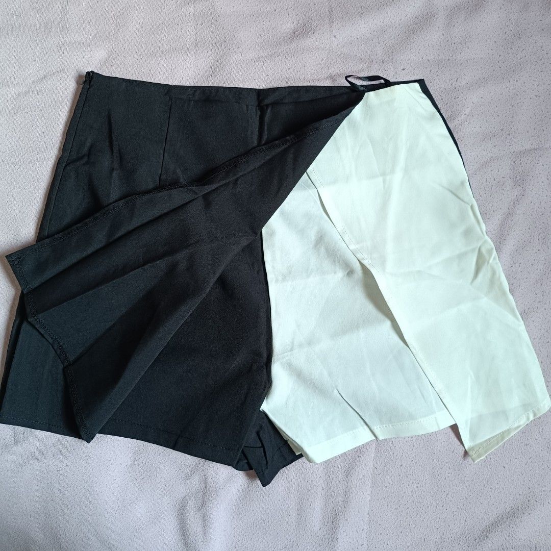 Shein Black Skirt Size S (Category: Skirts) located in Manila. Submitted by its.me.jo (Listing ID 1468550124, Image 3). Description: - Brand: Shein - Style: Black mini skirt with asymmetric wrap detail (light mint/white underneath) - Size: S / EU 36 / US 4 - Closure: Side zipper - Condition: Clean fabric - Perfect for styling with basic tees and blouses.