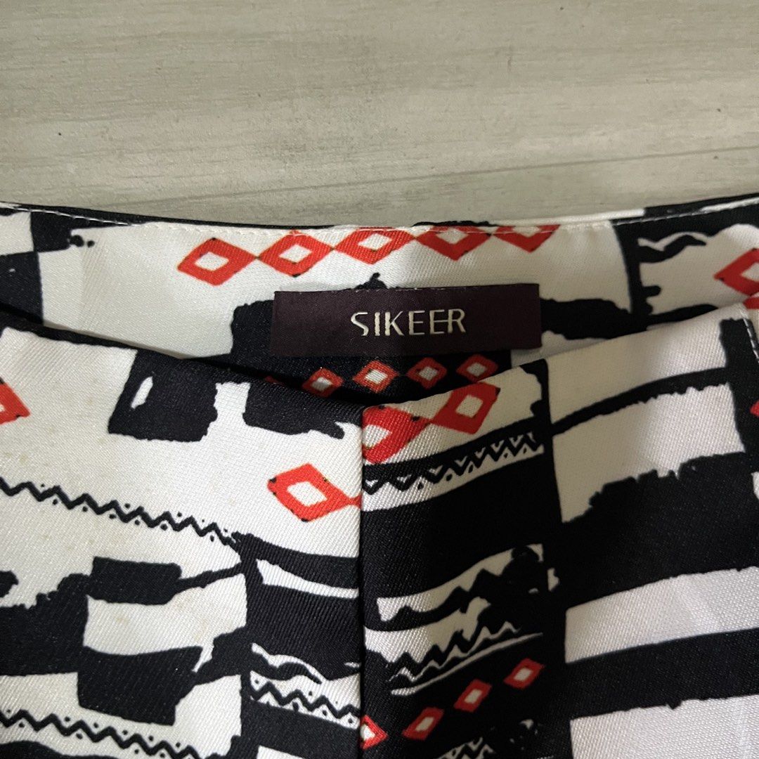 SIKEER Black White Geometric Print Shorts (Category: Shorts) located in Malabon City. Submitted by lunapie (Listing ID 1468615972, Image 3). Description: - Brand: SIKEER - Design: Striking black and white abstract print with small red diamond accents - Fabric & Fit: Smooth finish with a structured cut - Closure: Clean, hidden waistline closure - Style: Perfect statement piece for warm weather.