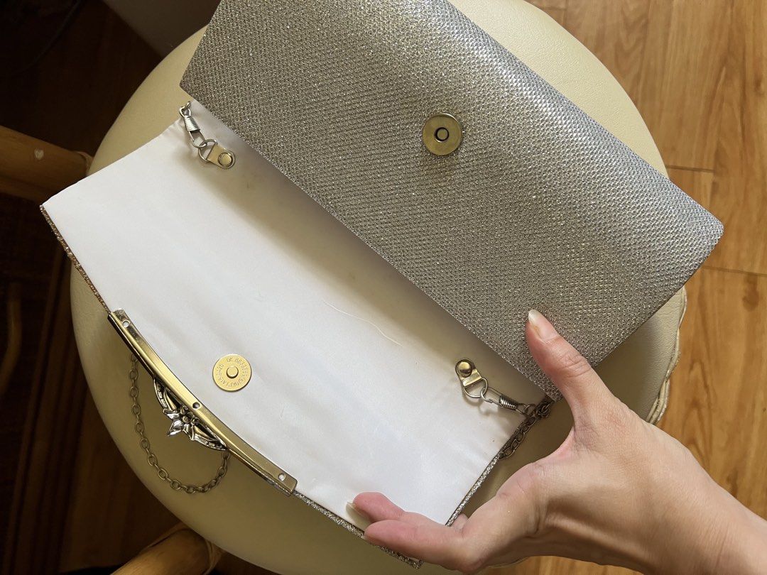 Silver Glitter Evening Clutch Bag with Chain (Category: Clutches) located in Rizal. Submitted by s0apandglory (Listing ID 1468554642, Image 2). Description: - Color/Material: Silver glitter with textured fabric - Hardware: Sleek metallic detail on front flap - Closure: Secure magnetic snap - Interior: Clean white lined compartment - Strap: Includes detachable silver chain for shoulder wear - Occasion: Compact and chic for parties, weddings, and f