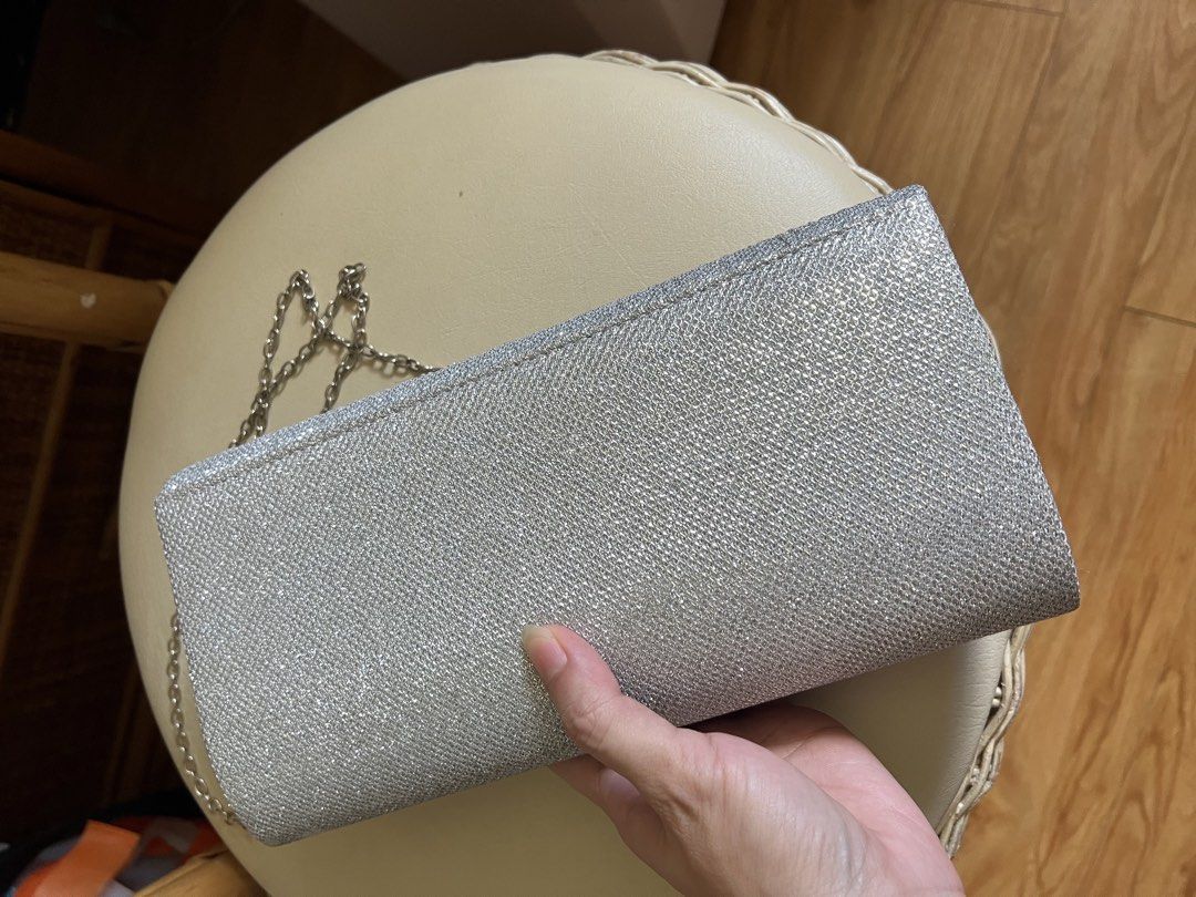 Silver Glitter Evening Clutch Bag with Chain (Category: Clutches) located in Rizal. Submitted by s0apandglory (Listing ID 1468554642, Image 3). Description: - Color/Material: Silver glitter with textured fabric - Hardware: Sleek metallic detail on front flap - Closure: Secure magnetic snap - Interior: Clean white lined compartment - Strap: Includes detachable silver chain for shoulder wear - Occasion: Compact and chic for parties, weddings, and f