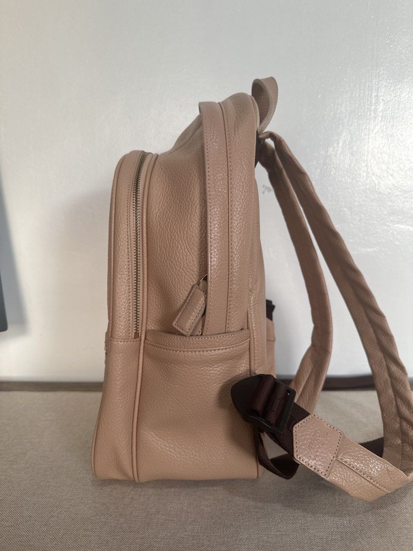 St. Scott London Leather Backpack in Cream (Category: Backpacks) located in Cainta. Submitted by xyzasisa (Listing ID 1468585154, Image 3). Description: - Brand: St. Scott London - Size: height-14.5 in, width-9.5 in, base-4.5in - Material: Premium beige pebbled leather with gold hardware - Exterior: Front zipper pocket with stylish stud details and a trendy quilted zigzag back panel - Interior: Clean burgundy lining featuring all-over printed bra
