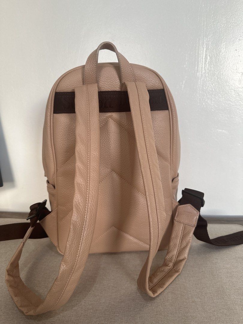 St. Scott London Leather Backpack in Cream (Category: Backpacks) located in Cainta. Submitted by xyzasisa (Listing ID 1468585154, Image 2). Description: - Brand: St. Scott London - Size: height-14.5 in, width-9.5 in, base-4.5in - Material: Premium beige pebbled leather with gold hardware - Exterior: Front zipper pocket with stylish stud details and a trendy quilted zigzag back panel - Interior: Clean burgundy lining featuring all-over printed bra
