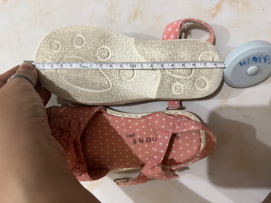 Stone Play Pink Polka Dot Sandals Size 18cm (Category: Flats & Sandals) located in Taguig. Submitted by heideewatts (Listing ID 1468618616, Image 2). Description: - Brand/Style: Stone Play pink sandals with white polka dots - Size: 19vm length (measured with tape) - Design Details: Adorable front bow and adjustable ankle strap with metal buckle - Comfort & Safety: Sturdy, textured soles with decent grip - Condition: Pre-owned with light wear on t
