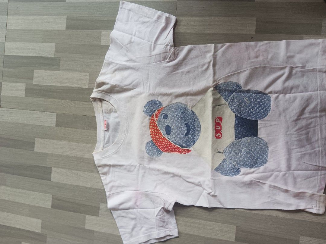 Supreme Bear Graphic White T-Shirt Size L (Category: Tshirts & Polo Shirts ) located in Manila. Submitted by charleshustla (Listing ID 1468534281, Image 1). Description: - White graphic t-shirt with teddy bear, red bandana, and SUP box logo design - Size: Large (tag inside collar) - Material: 100% pre-shrunk cotton, made in USA - Comfort: Soft and comfortable cotton fabric - Condition: Noticeable yellowing around the neckline from previous wear -