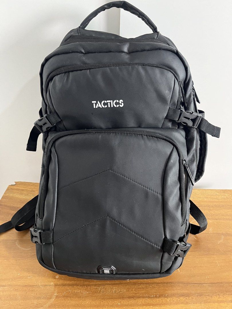 Tactics Black Backpack (Category: Backpacks) located in Mandaluyong City. Submitted by unomarcelo001 (Listing ID 1468540056, Image 1). Description: - Color: Classic Black - Brand: Tactics - Storage: Multiple spacious compartments with ample capacity - Adjustability: Side buckle straps to secure and adjust volume - Comfort: Top carry handle and thick padded shoulder straps - Authenticity: Interior tag shows production details and branding - Condit
