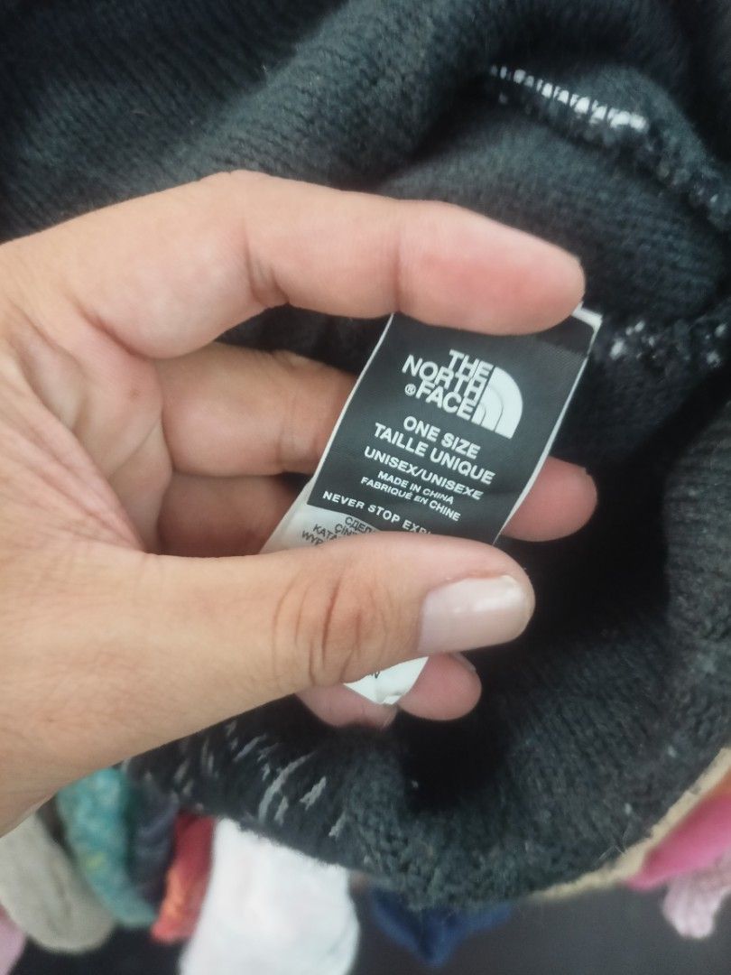 The North Face Black Knit Beanie (Category: Caps & Hats) located in Cavite. Submitted by ronniel0943882 (Listing ID 1468608722, Image 3). Description: - Brand: The North Face - Color: Black with white dashed logo pattern - Material: Thick knit construction for maximum warmth - Size: One size fits all (Unisex) - Details: Features a small woven brand tag near the bottom edge - Condition: Excellent for outdoor trips and casual winter wear.