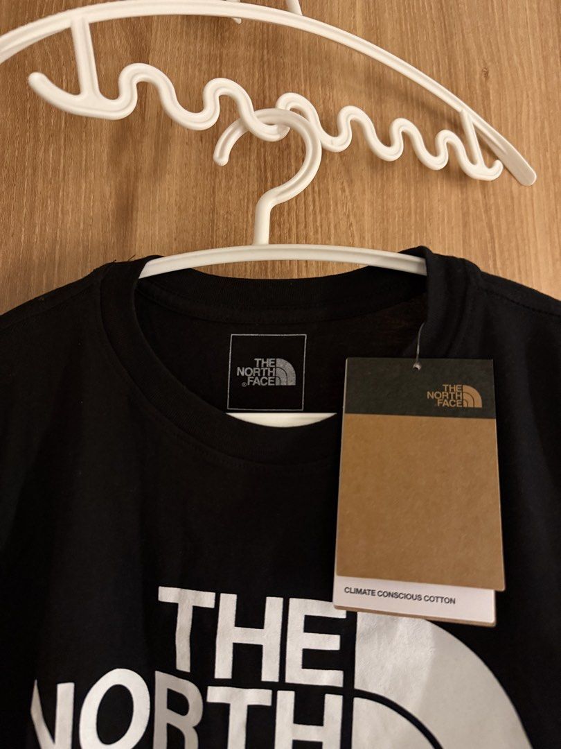The North Face Black T-Shirt M (Category: Shirts) located in Manila. Submitted by conradfisher (Listing ID 1468631472, Image 2). Description: - Brand: The North Face - Color: Black with large white chest logo - Size: Medium (tag attached) - Fit: Regular fit with classic crew neck and short sleeves - Material: Climate-conscious cotton - Condition: Brand new with original tags.