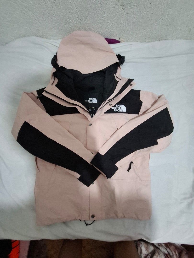 The North Face Gore-Tex Pink Black Jacket Size M (Category: Coats, Jackets and Outerwear) located in Manila. Submitted by necklie_tuballas (Listing ID 1468657184, Image 1). Description: - Brand: The North Face - Material: Gore-Tex waterproof shell - Colorway: Light pink and black - Size: Unisex Medium (M) - Origin: Made in Vietnam - Features: Attached hood with drawstrings, full zip front with snap-button storm flap - Details: All interior tags i