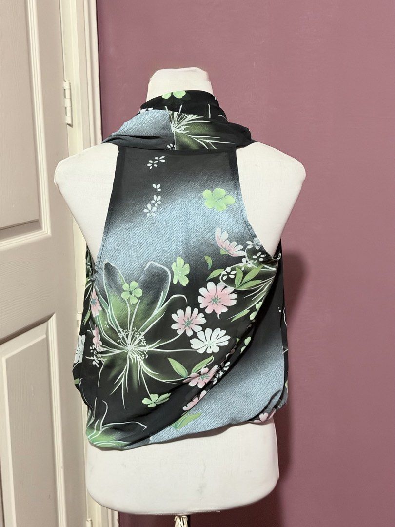Thin floral low neck aesthetic top whimsy (Category: Sleeveless) located in Manila. Submitted by thatgirl0001 (Listing ID 1468598834, Image 3). Description: - Style: Sleeveless top with a draped wrap-around front design - Design: Black base with colorful pink floral pattern and light blue panel accents - Material: Lightweight fabric, ideal for warm weather styling - Condition: Excellent, ready to wear - Perfect for: Casual outings, dates, or summ