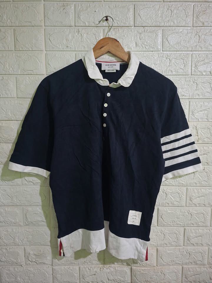 Thom Browne Polo Shirt (Category: Others Tops) located in Bulacan. Submitted by bleue.finds (Listing ID 1468574941, Image 1). Description: Thom Browne Polo Shirt - size 2 - 20 width - 26 length - as new - minor yellowish stain on collar - good condition .