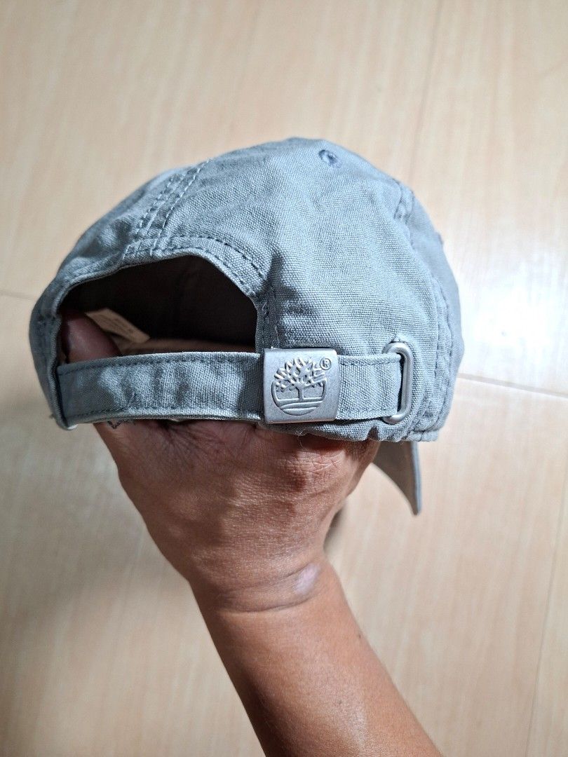 Timberland Grey Baseball Cap with Leather Patch (Category: Caps & Hats) located in Baguio. Submitted by restyrille77846 (Listing ID 1468642511, Image 3). Description: - Authentic Timberland cap in versatile grey - Sturdy canvas material with structured brim and ventilation eyelets - Features iconic diamond-shaped leather patch with tree logo and 1973 branding - Adjustable strap with metal slide buckle and embossed logo clasp - RFS: Closet clearou