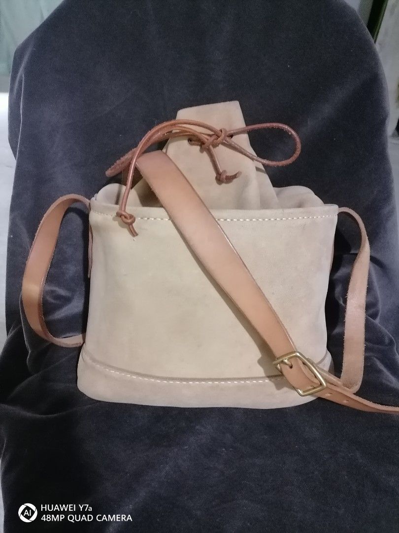 Timberland Suede Bucket Bag Tan Leather Strap (Category: Cross-body Bags) located in Naga. Submitted by mrwisethrifter (Listing ID 1468513930, Image 2). Description: - Brand: Timberland - Material: Soft tan suede with contrast stitching - Closure: Drawstring with leather cord - Strap: Adjustable shoulder strap with brass hardware - Interior: Clean with a zip pocket and signature tree logo pull - Condition: Excellent, functional hardware - Perfect