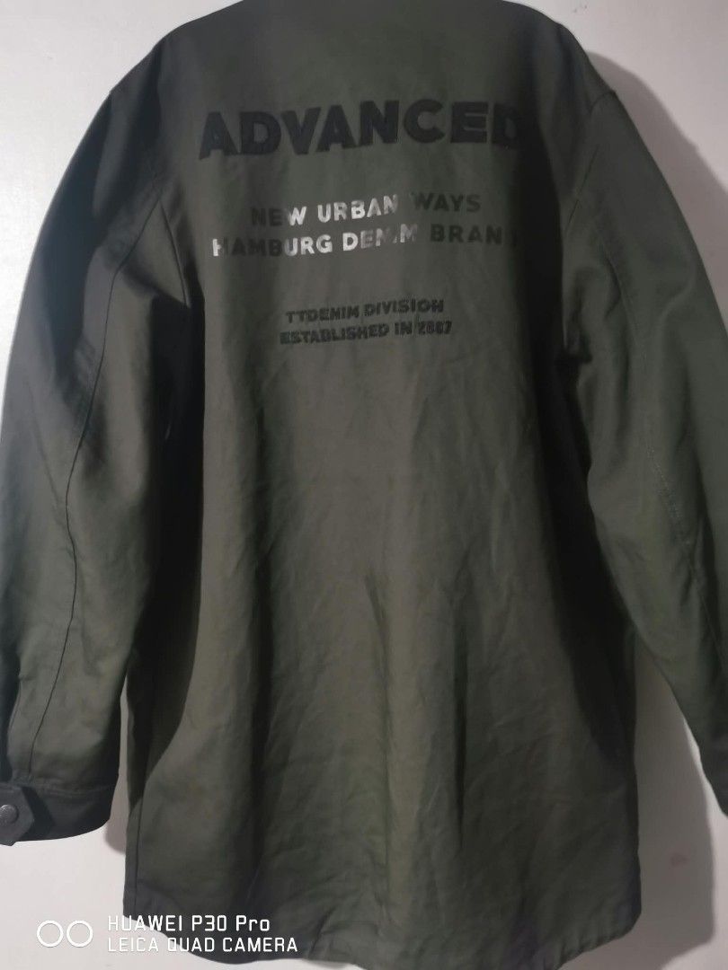 Tom Tailor Denim Green Bomber Jacket Size M (Category: Coats, Jackets and Outerwear) located in Makati City. Submitted by relianzmae57131 (Listing ID 1468644731, Image 3). Description: - Brand: Tom Tailor Denim - Color: Dark Green - Size: Medium (M) - Design: Button-up front, flap pockets, and large "ADVANCED NEW URBAN WAYS HAMBURG DENIM BRAND" back graphic - Interior: Soft grey fabric lining for extra comfort - Condition: Great weight, ideal for