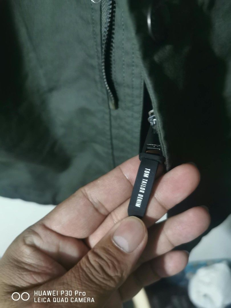 Tom Tailor Denim Green Bomber Jacket Size M (Category: Coats, Jackets and Outerwear) located in Makati City. Submitted by relianzmae57131 (Listing ID 1468644731, Image 2). Description: - Brand: Tom Tailor Denim - Color: Dark Green - Size: Medium (M) - Design: Button-up front, flap pockets, and large "ADVANCED NEW URBAN WAYS HAMBURG DENIM BRAND" back graphic - Interior: Soft grey fabric lining for extra comfort - Condition: Great weight, ideal for