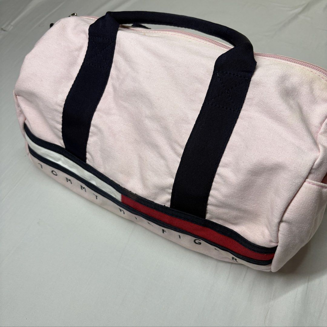 Tommy Hilfiger Pink Canvas Small Duffel Bag (Category: Shoulder Bags) located in Angeles City. Submitted by muse_archive (Listing ID 1468632539, Image 2). Description: -Tommy Hilfiger with dark blue shoulder strap and carry handles - Top zip closure with dark interior lining -issues: some yellowish staining (hindi masyadong halata) -super clean ng interior .