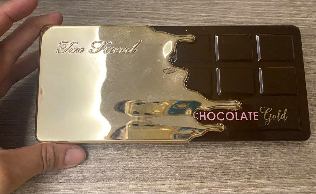 Too Faced Chocolate Gold Eyeshadow Palette (Category: Makeup) located in Makati City. Submitted by larasdowry (Listing ID 1468710722, Image 1). Description: Authentic Too Faced Chocolate Gold Eyeshadow Palette in a stunning gold drip metal case with a built-in mirror. Features 16 rich metallic and matte shades like Money Bags, New Money, Rich Girl, and Decadent. Perfect for creating glam looks!.