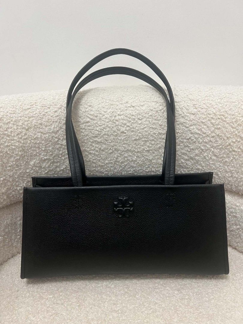 Tory Burch Thea East West Shoulder Bag (Category: Shoulder Bags) located in Paoay. Submitted by rvf1230 (Listing ID 1468545544, Image 2). Description: - Authentic Tory Burch black leather shoulder bag - Structured rectangular shape with a minimalist design - Subtle debossed logo on the front face - Comfortable thin shoulder straps - Clean edge and base stitching - Spacious interior for all your daily essentials - Condition: Excellent / Grab it be