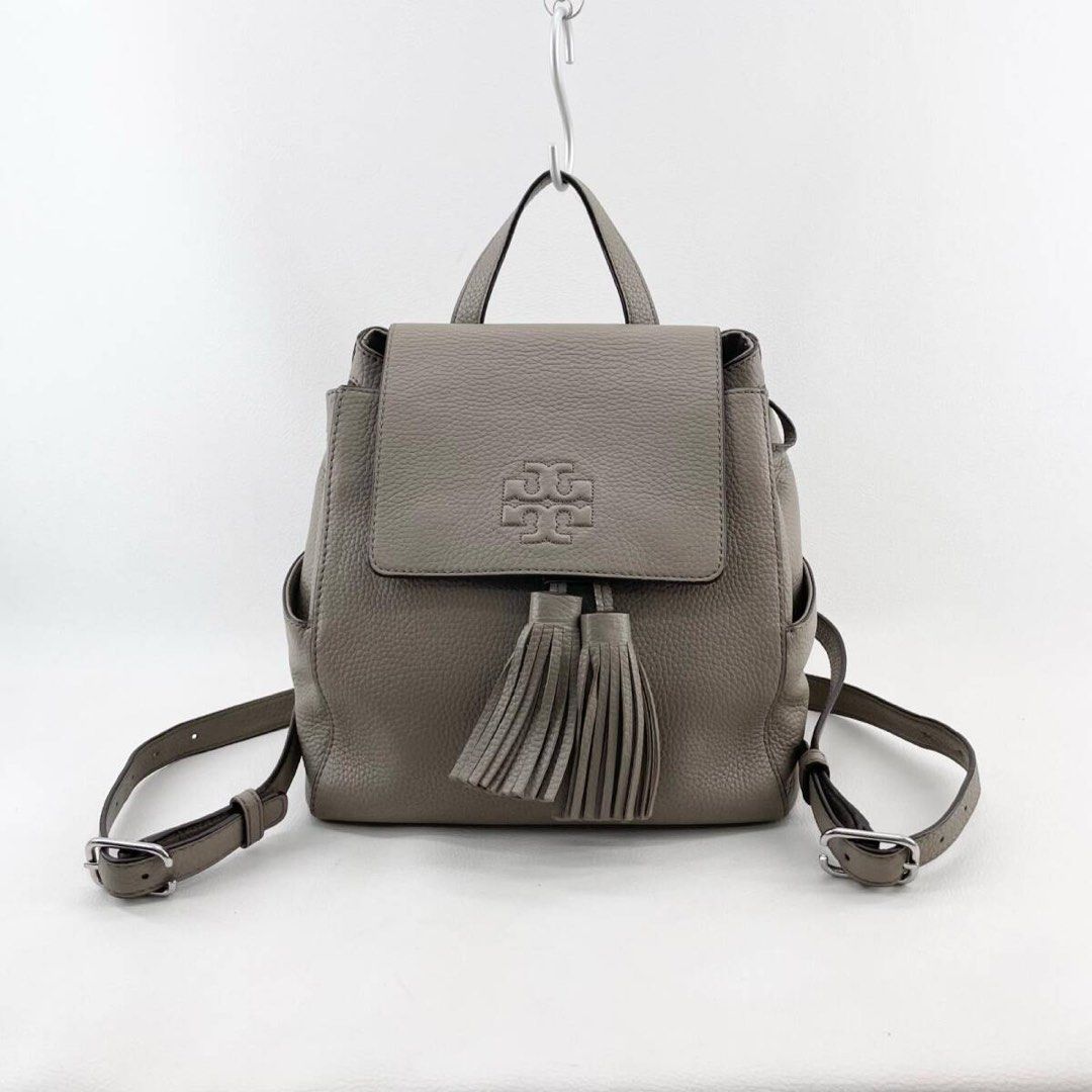 Tory Burch Thea Mini Backpack (Category: Luxury Bags & Wallets) located in Manila. Submitted by jizamarie (Listing ID 1468615376, Image 1). Description: The perfect everyday hands-free neutral! Beautiful French Gray pebbled leather with the signature embossed logo and tassels. ✨ DM for inquiries or more close-up details! 📥.